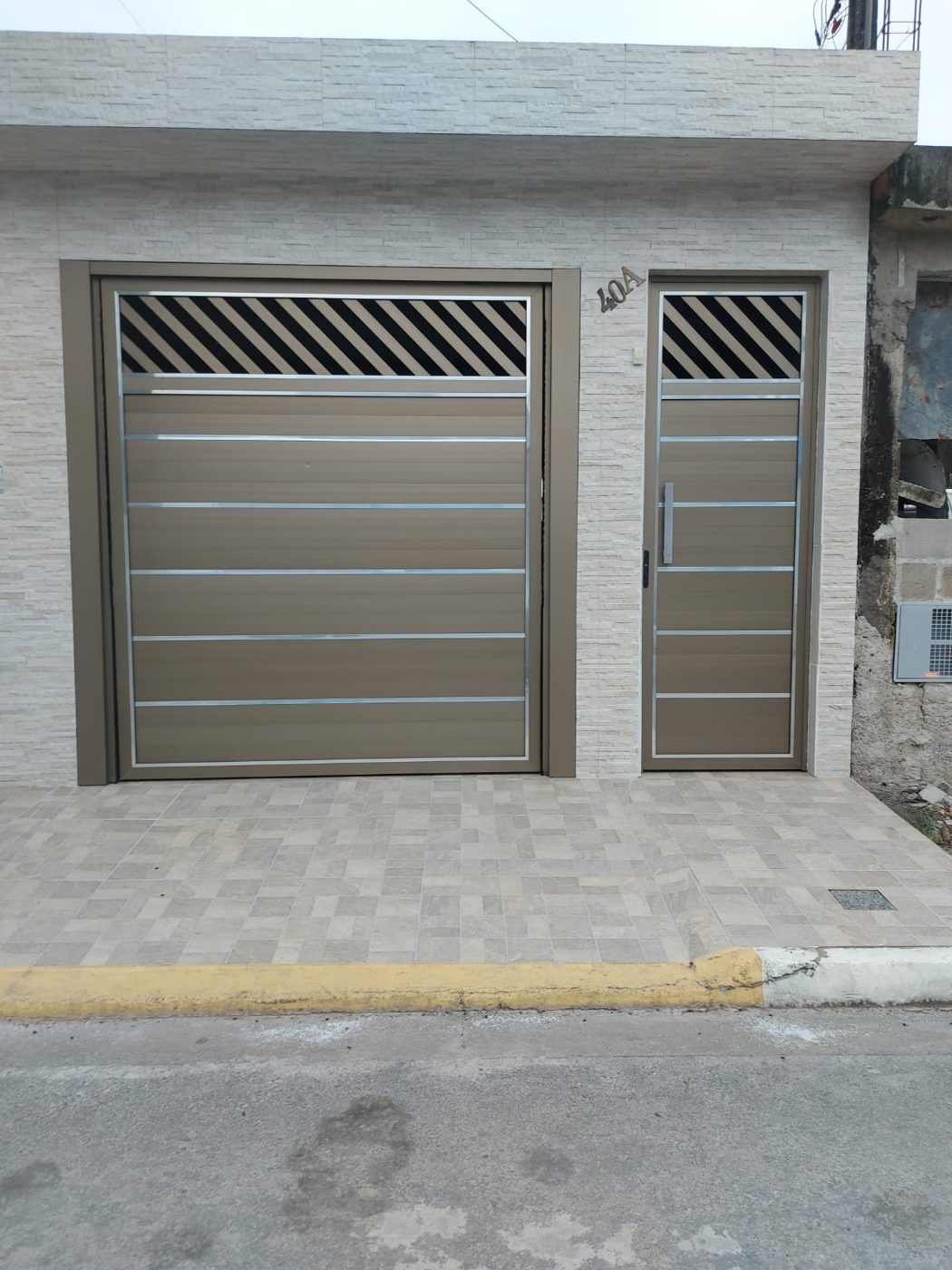 Portão nº 20: Basculante com porta social em lambril duplo champanhe, detalhes brilhantes e puxador H