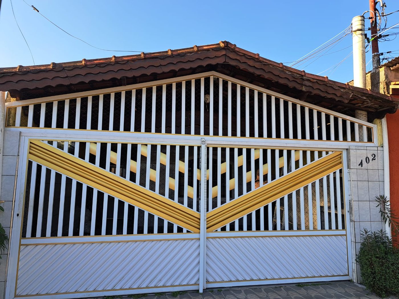 Portão nº 23: 2 folhas deslizantes em mini búzio com grades verticais e acabamento dourado